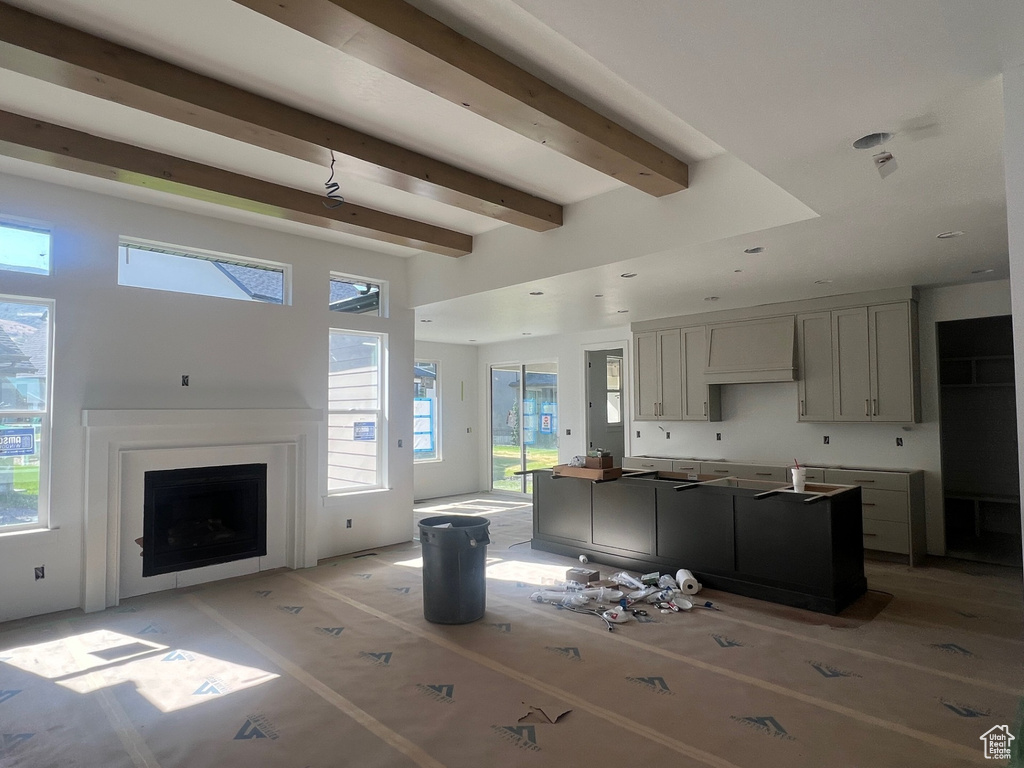 Kitchen featuring beamed ceiling, a kitchen island, and a fireplace