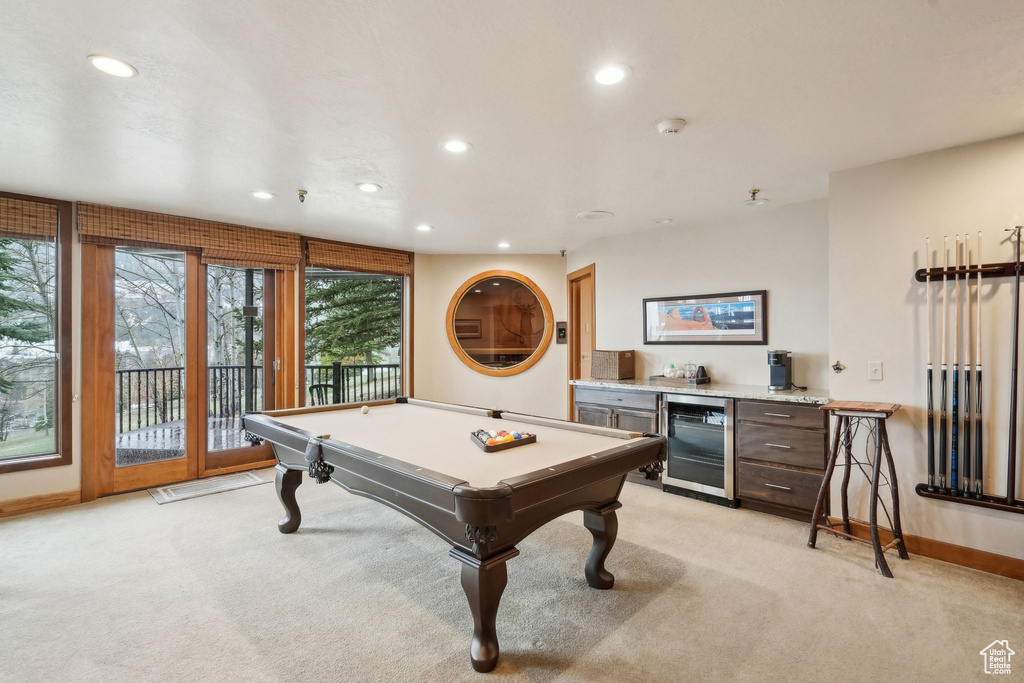 Recreation room featuring a bar, light colored carpet, beverage cooler, and recessed lighting