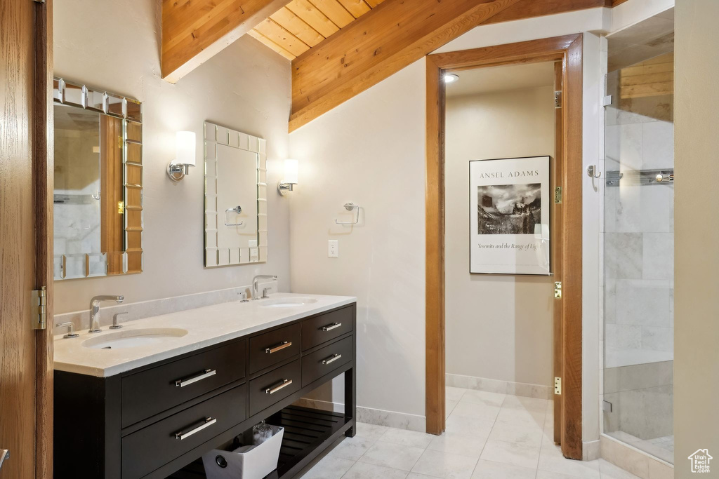 Full bath featuring a shower stall, double vanity, a sink, and beam ceiling