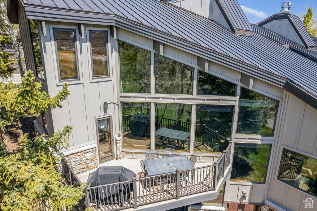 Exterior space with a standing seam roof, board and batten siding, a deck, and metal roof