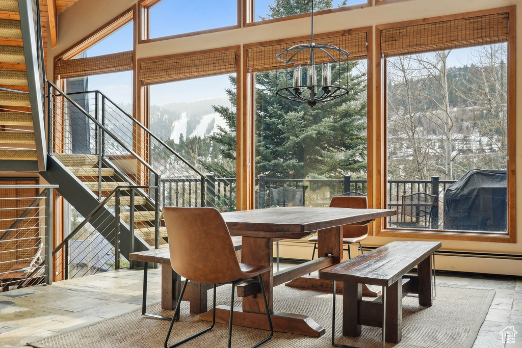 Sunroom with an inviting chandelier and baseboard heating