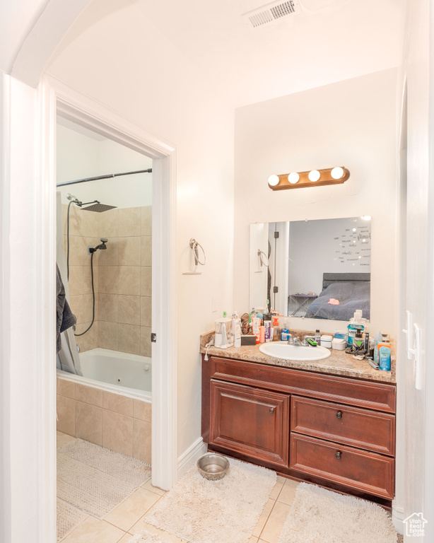 Full bath featuring visible vents, vanity, tiled shower / bath, connected bathroom, and tile patterned floors
