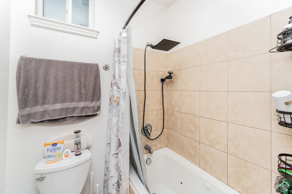 Full bath featuring shower / bath combo with shower curtain and toilet