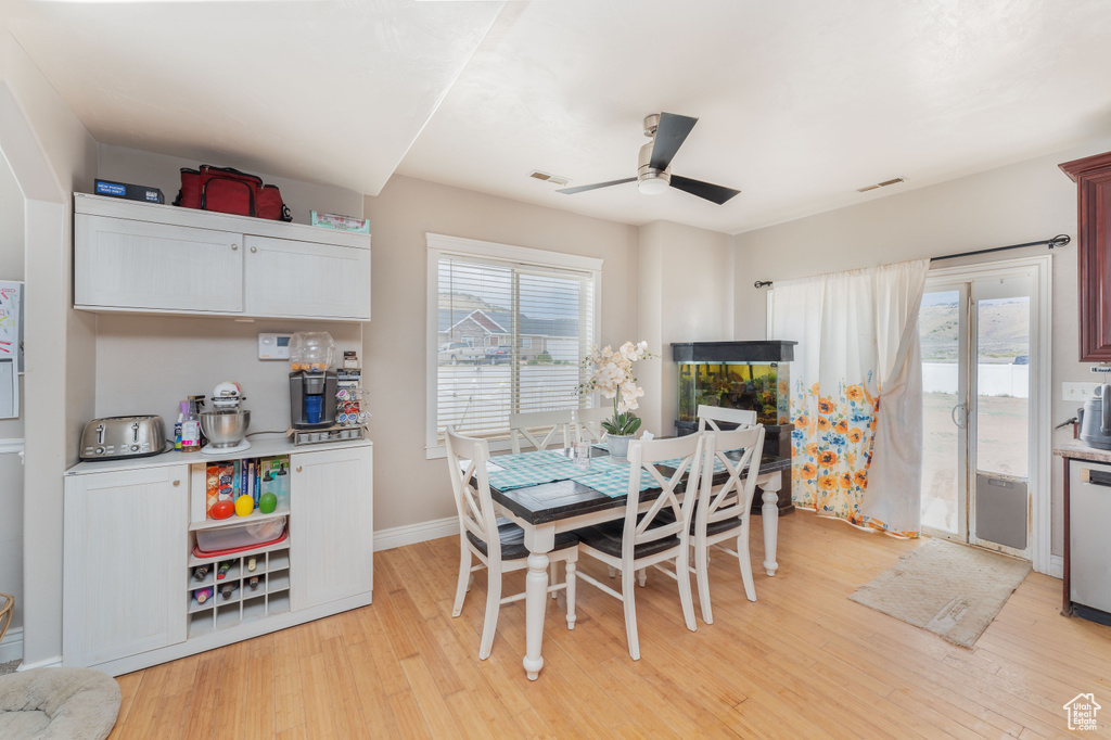 Dining room featuring baseboards, a ceiling fan, light wood finished floors, and visible vents