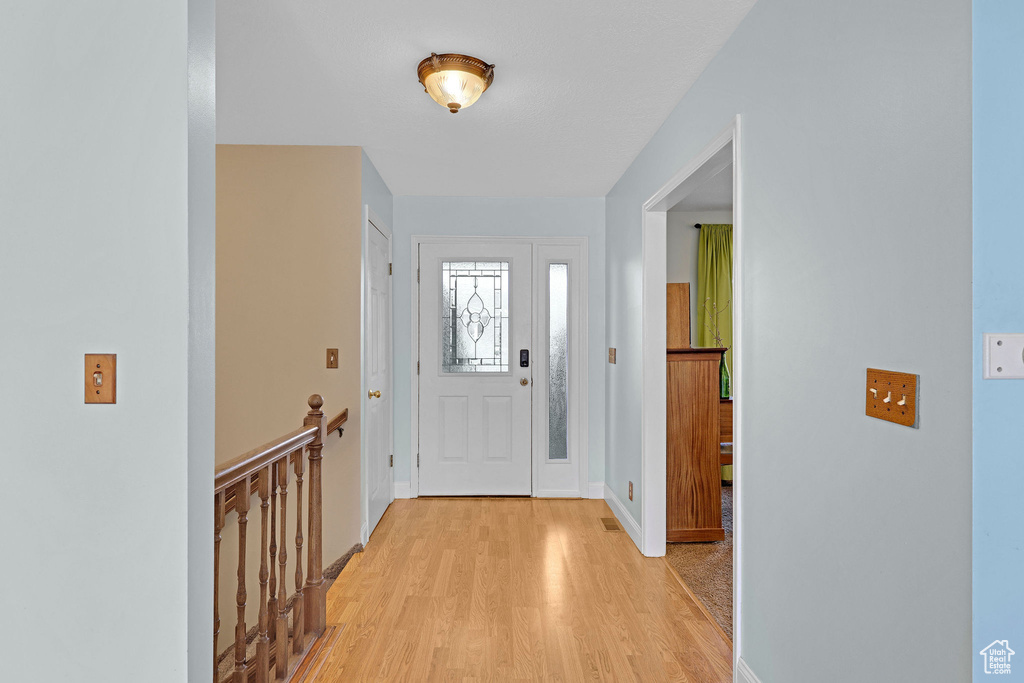 Foyer with baseboards and light wood finished floors