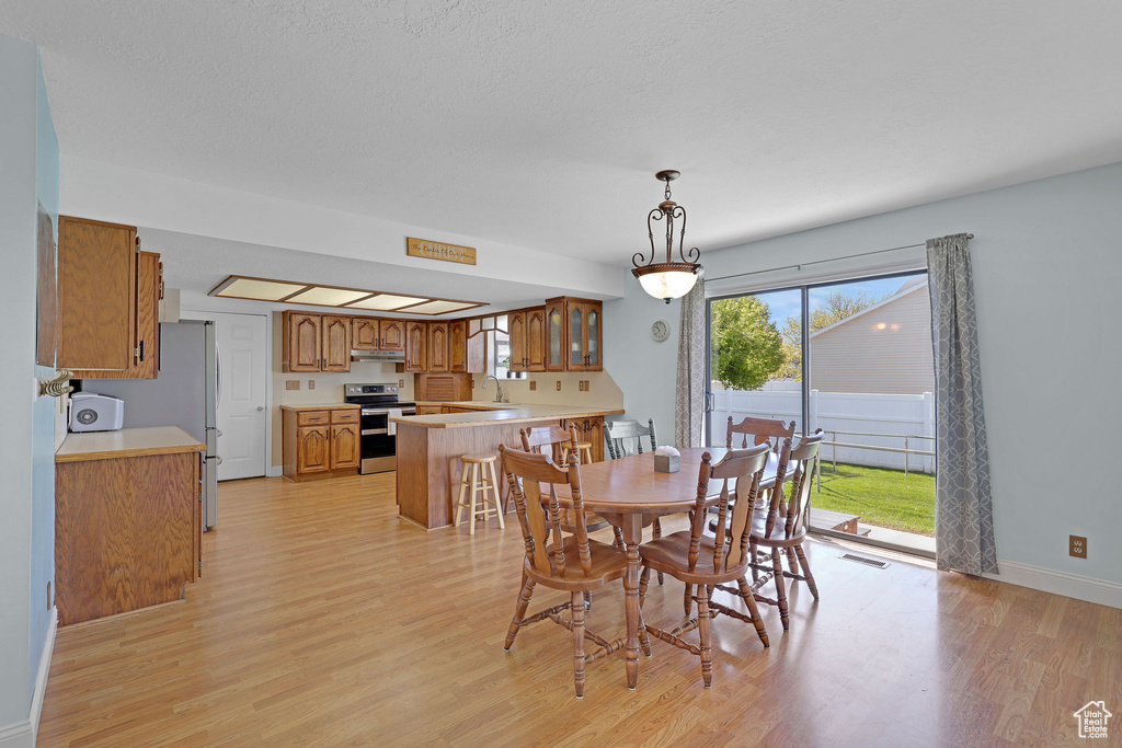 Dining area featuring baseboards, light wood-style flooring, and visible vents