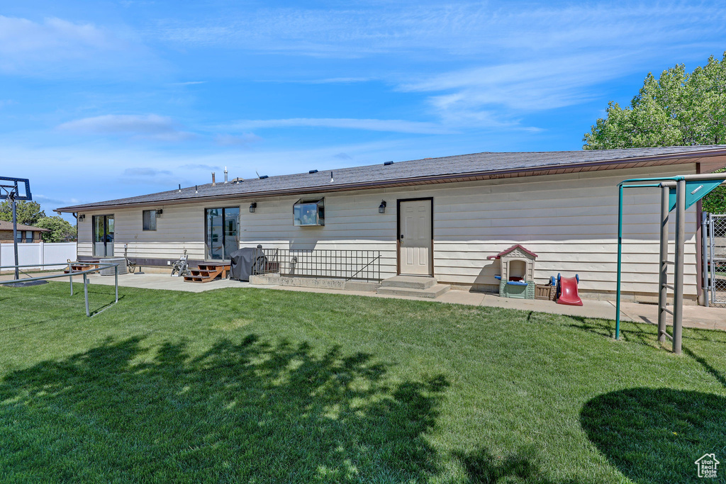 Rear view of house with a yard, entry steps, fence, and a patio area
