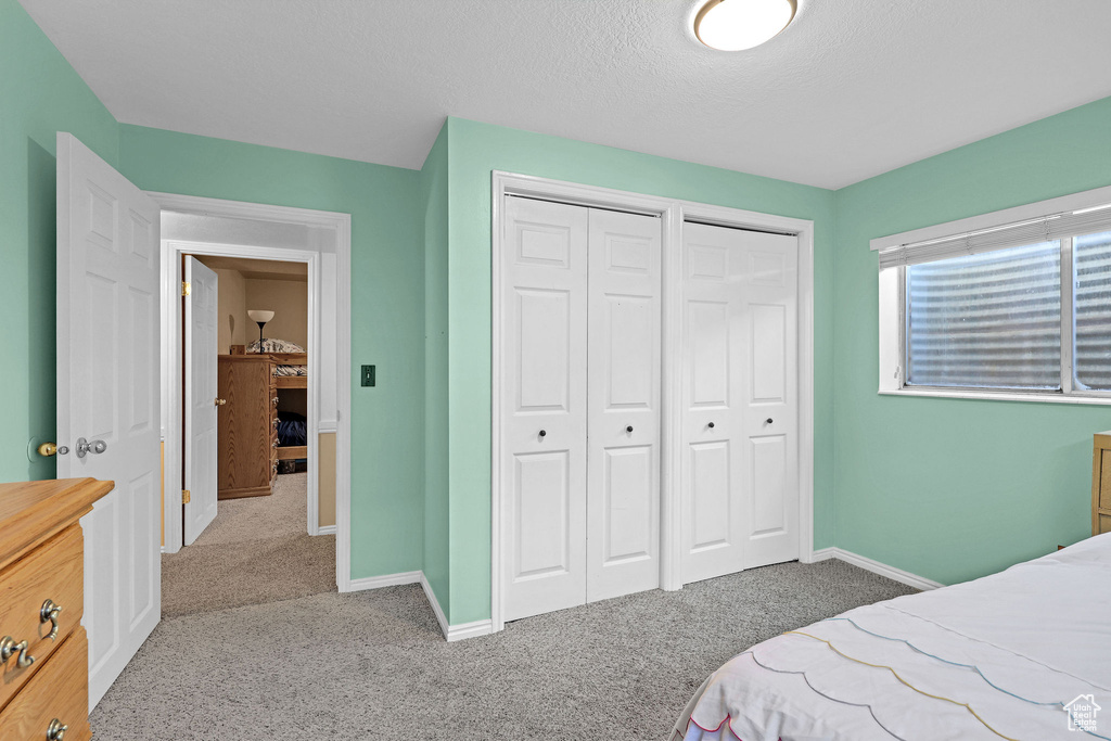 Bedroom featuring baseboards, carpet flooring, and two closets