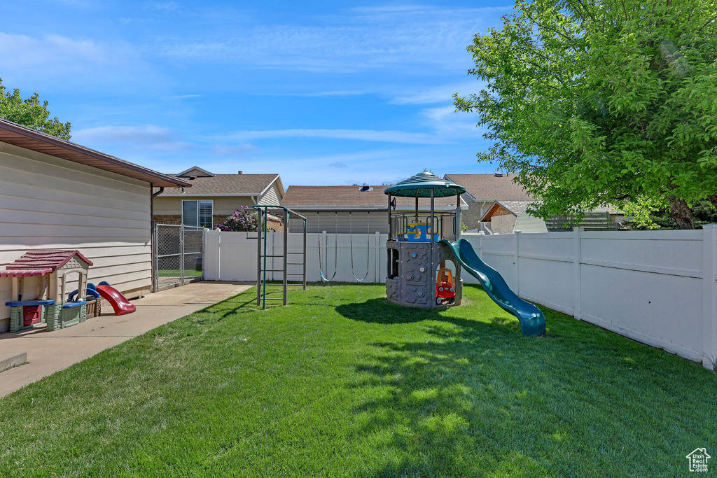 View of yard featuring a playground and a fenced backyard