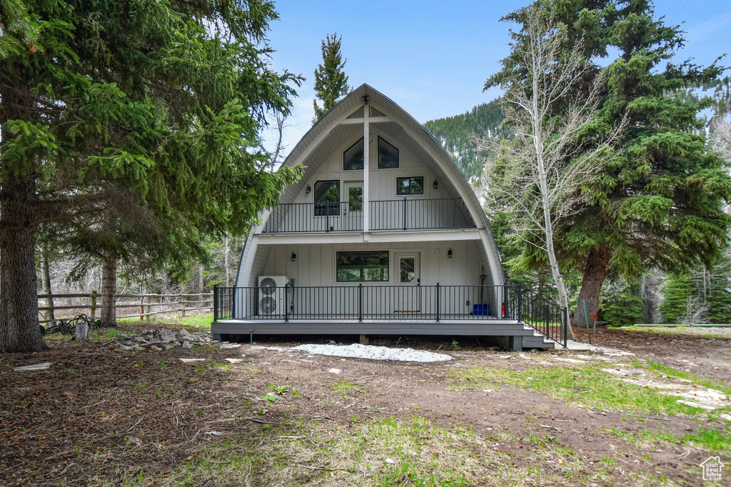 Back of house with fence and a gambrel roof