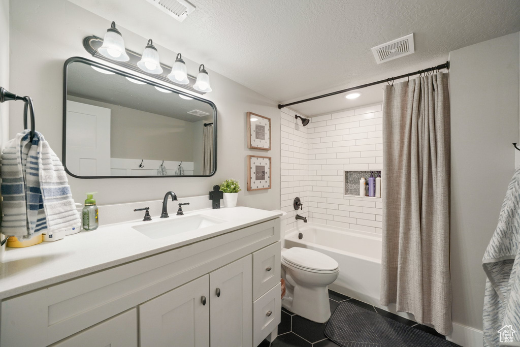 Bathroom featuring visible vents, shower / bath combo with shower curtain, toilet, and vanity