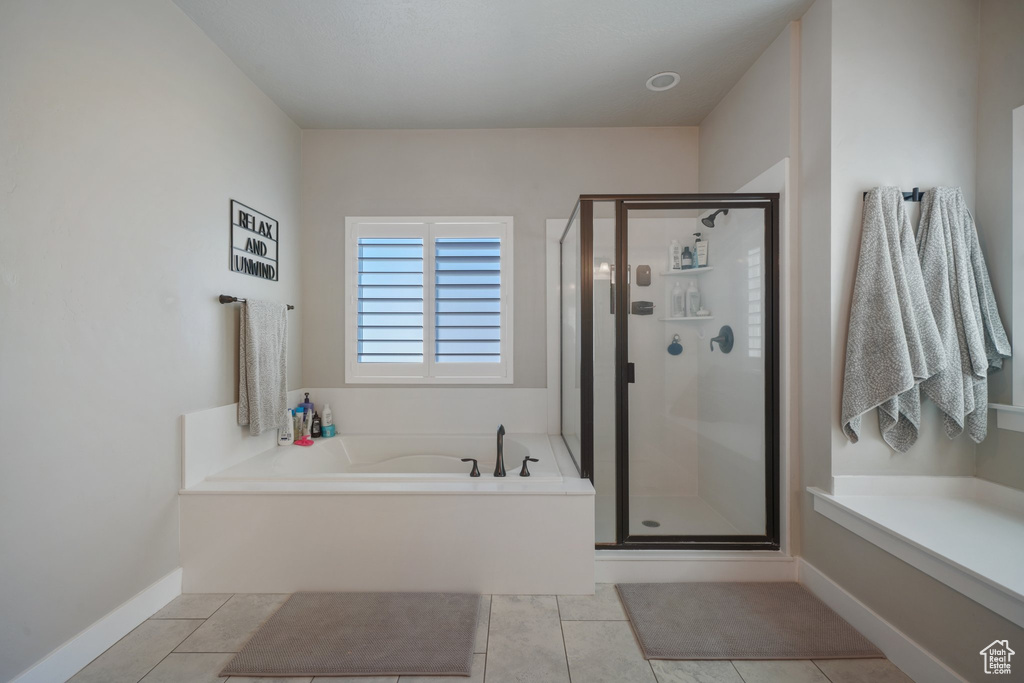 Bathroom with a garden tub, a stall shower, and tile patterned floors