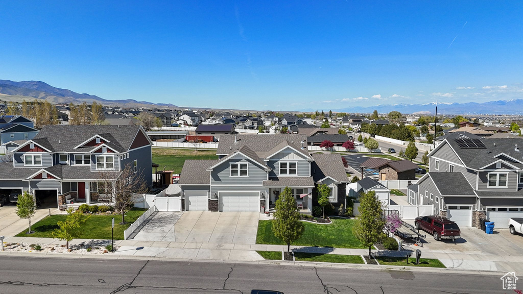 View of front facade with a residential view, a mountain view, concrete driveway, and a garage