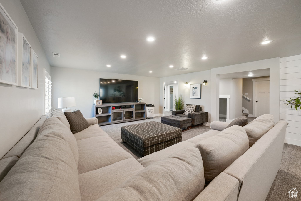 Living area with stairs, recessed lighting, visible vents, and carpet