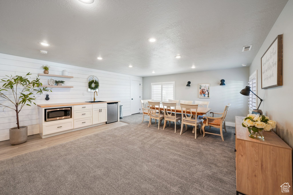 Dining area with recessed lighting, a textured ceiling, visible vents, and light carpet