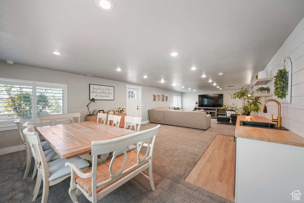 Carpeted dining space featuring a sink and recessed lighting
