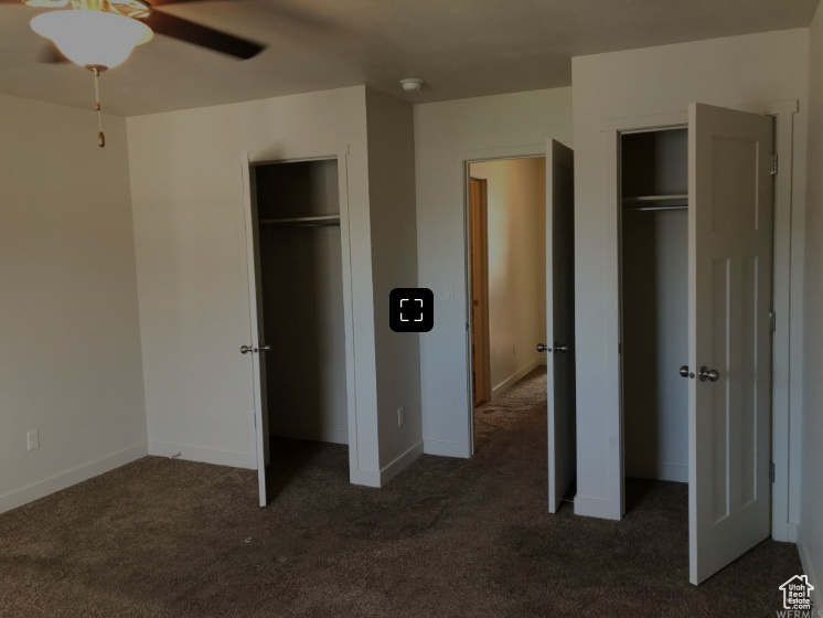 Unfurnished bedroom with baseboards, carpet flooring, and multiple closets