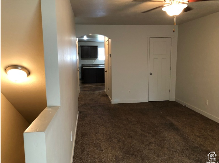 Interior space featuring arched walkways, ceiling fan, and baseboards