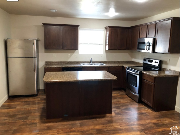 Kitchen featuring a sink, a kitchen island, stainless steel appliances, and dark brown cabinets