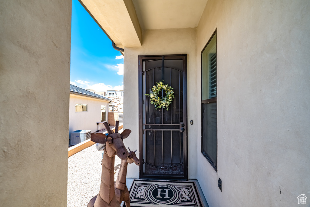 Property entrance with central air condition unit and stucco siding