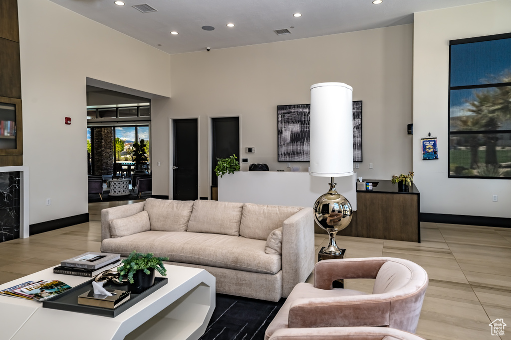 Living area with recessed lighting, baseboards, a towering ceiling, and visible vents
