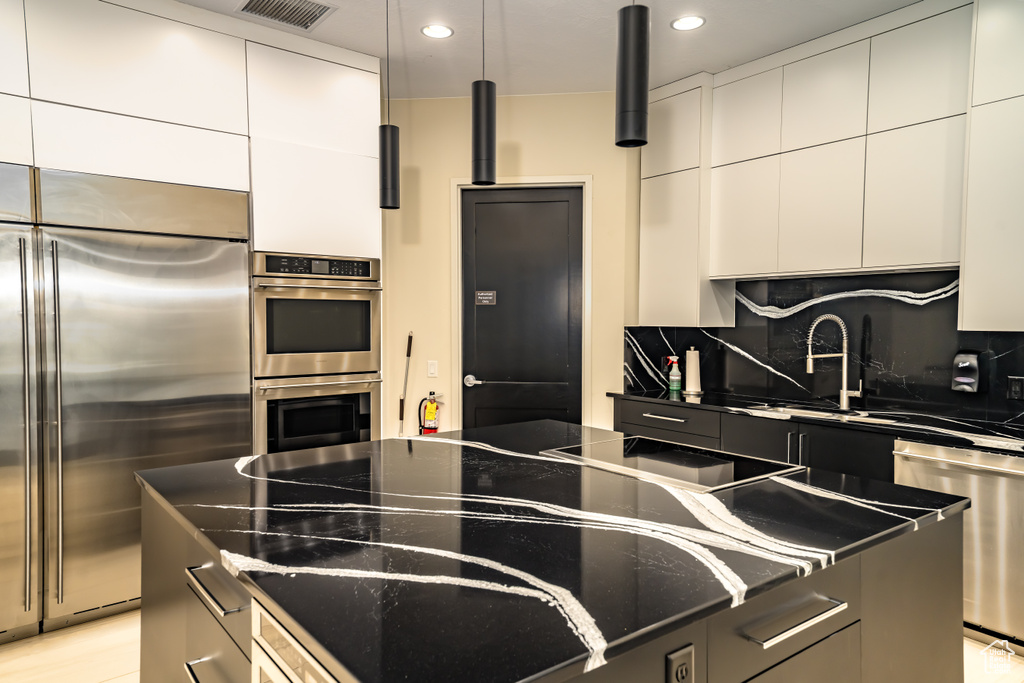 Kitchen featuring visible vents, modern cabinets, tasteful backsplash, stainless steel appliances, and recessed lighting
