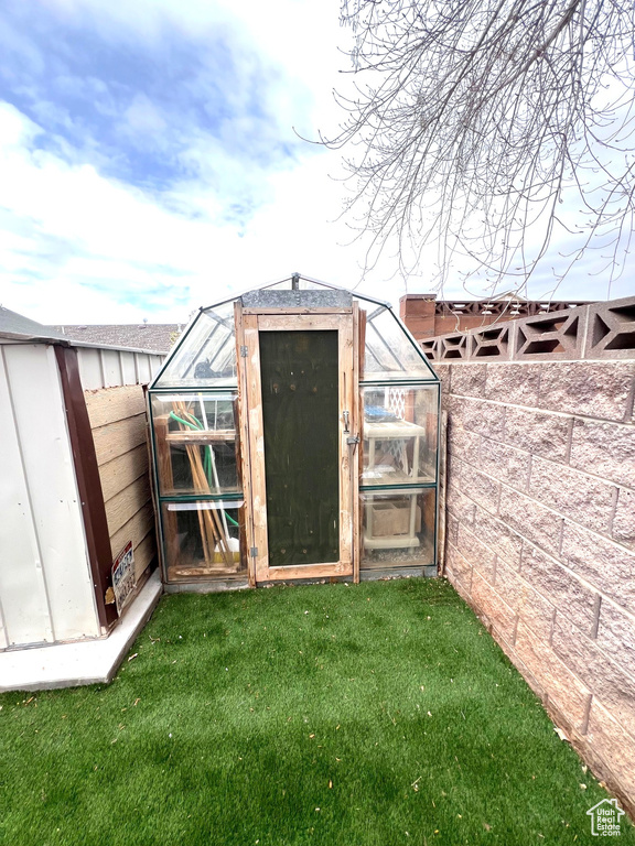 View of greenhouse featuring a yard