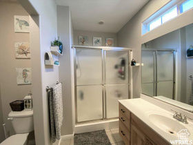 Bathroom with vanity, tile patterned flooring, a shower stall, and toilet