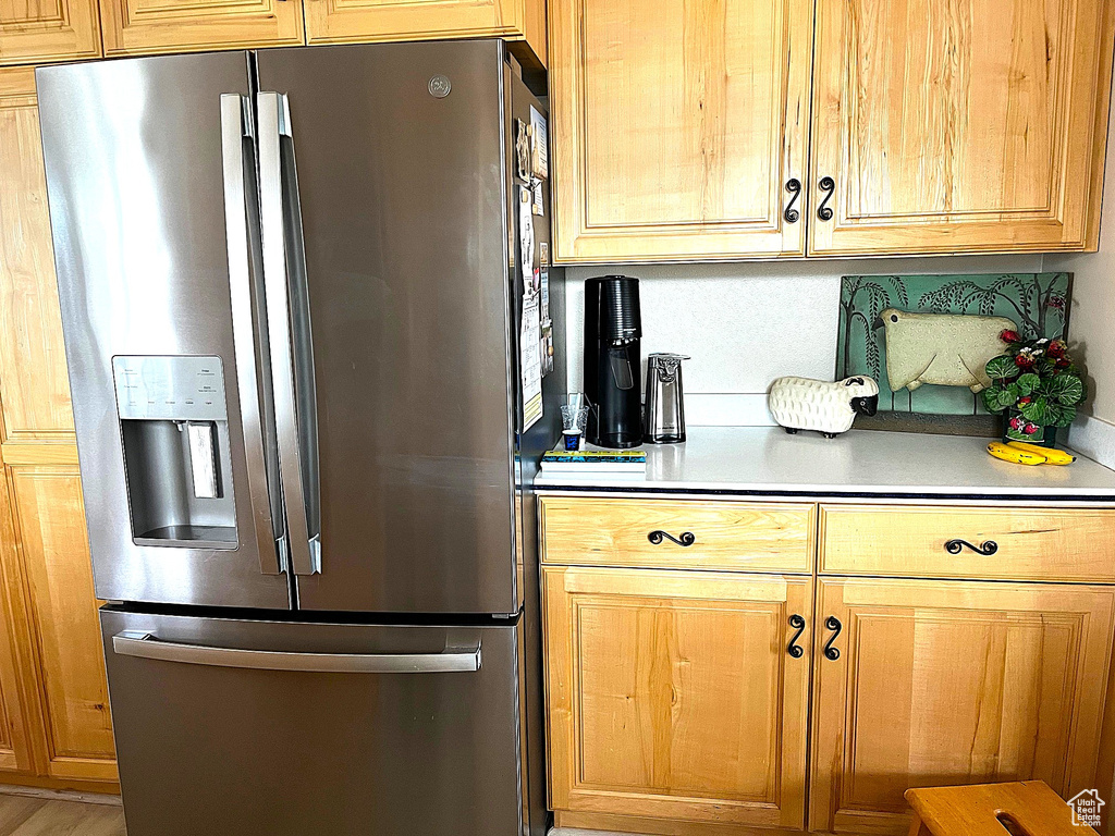 Kitchen with stainless steel fridge and light countertops