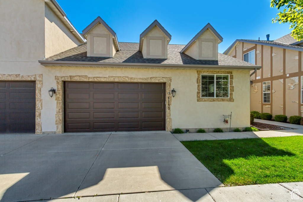Townhome / multi-family property featuring a garage, stucco siding, roof with shingles, and concrete driveway
