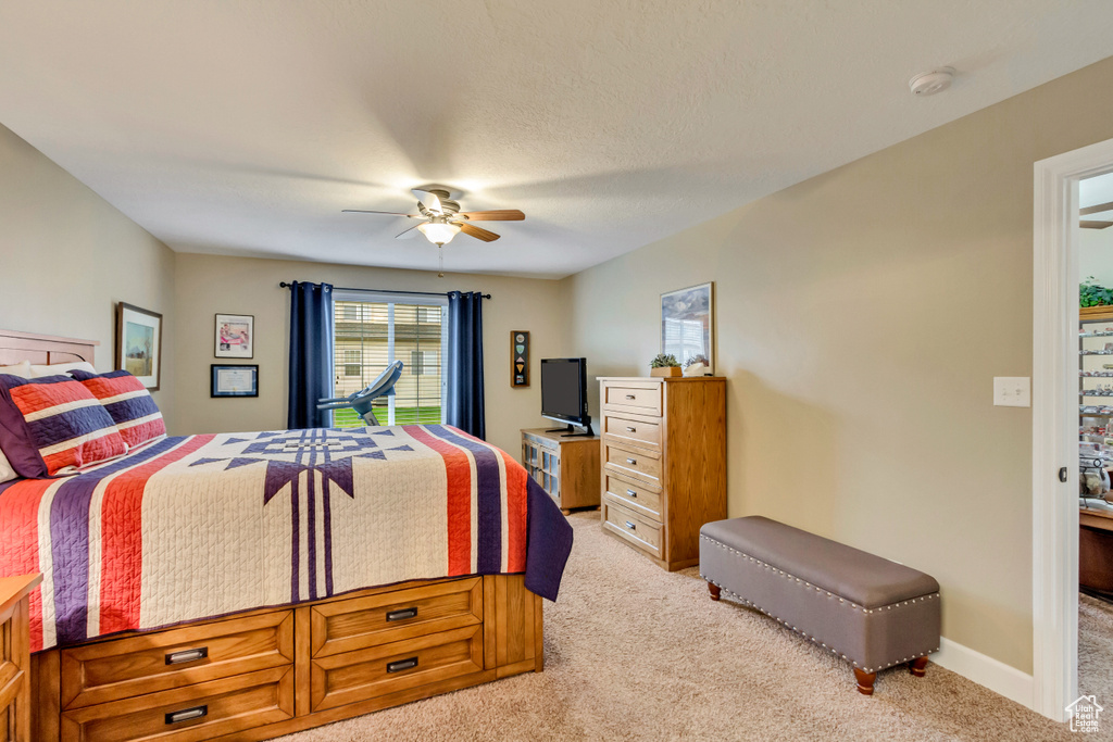 Bedroom with baseboards, a ceiling fan, and light colored carpet