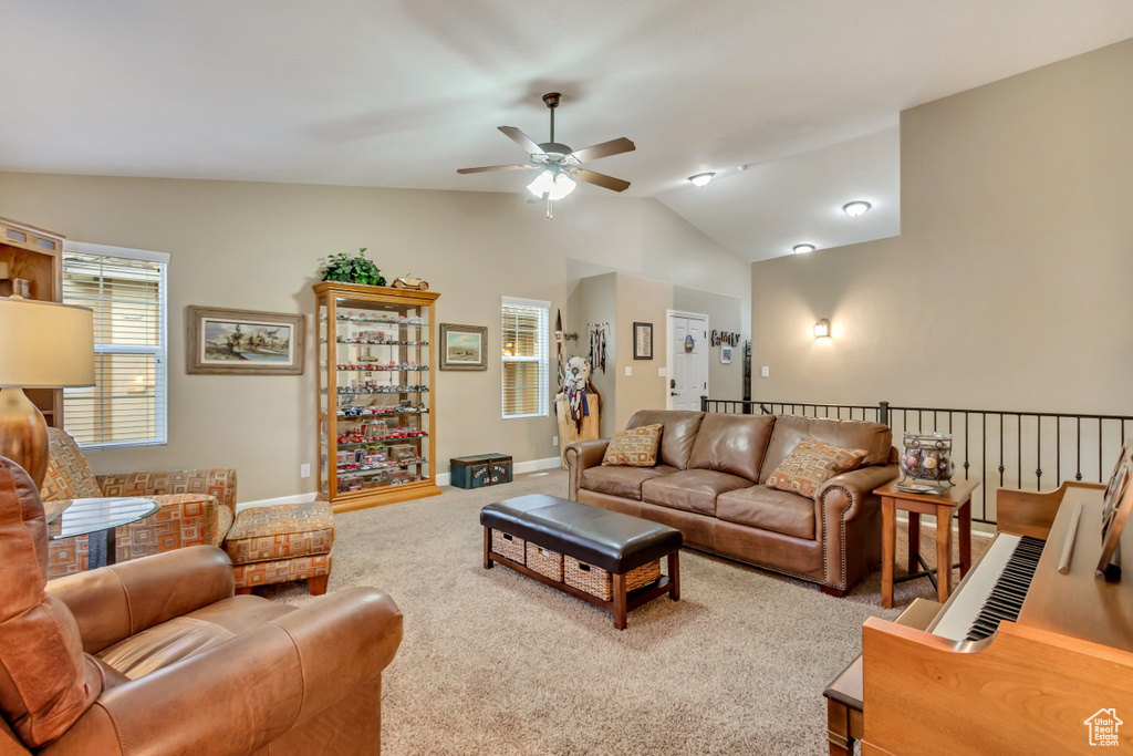 Living room featuring lofted ceiling, carpet floors, baseboards, and ceiling fan