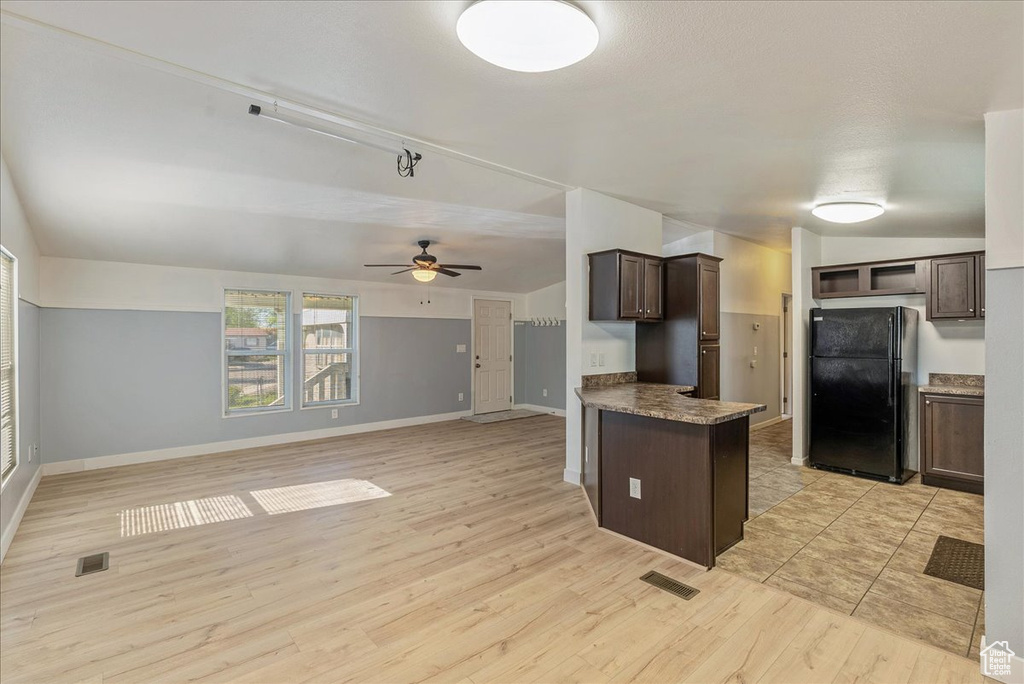 Kitchen featuring ceiling fan, dark brown cabinetry, visible vents, freestanding refrigerator, and light wood-style floors