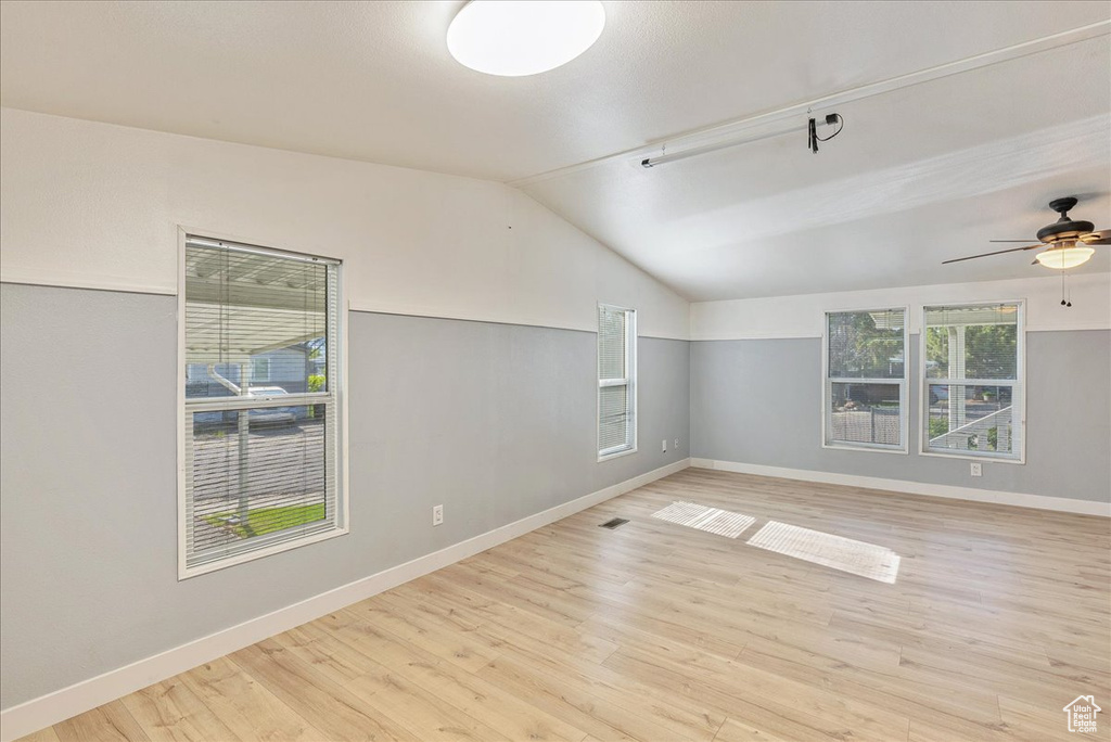 Spare room featuring baseboards, ceiling fan, wood finished floors, and lofted ceiling