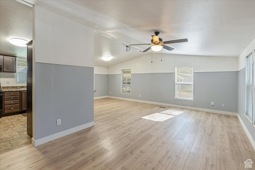 Bonus room with plenty of natural light, ceiling fan, light wood-style floors, and a textured ceiling