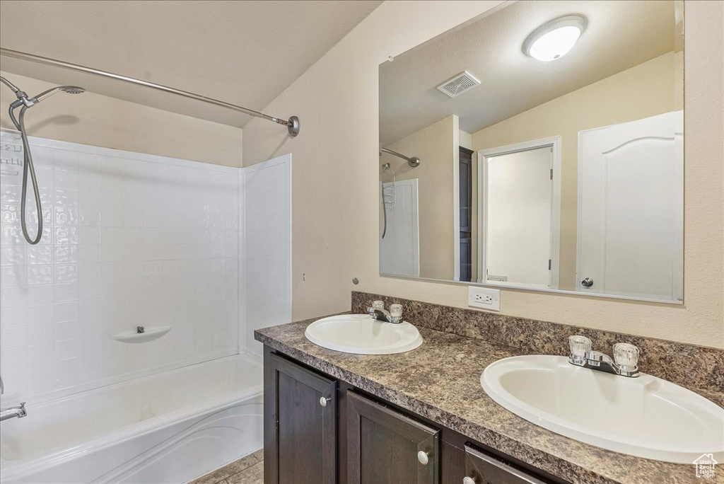 Full bath featuring a sink, bathing tub / shower combination, double vanity, and visible vents