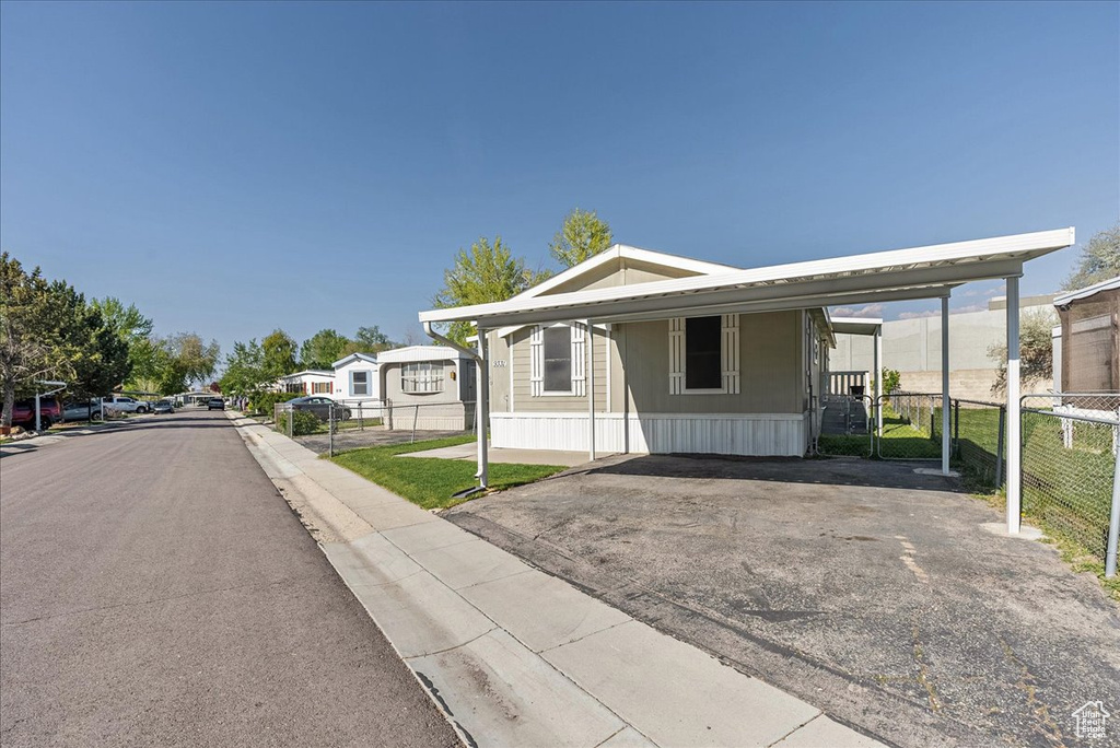 Exterior space featuring fence, a carport, and driveway