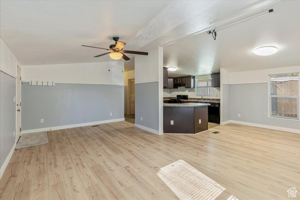 Kitchen featuring open floor plan, dark brown cabinetry, ceiling fan, and light wood-style floors