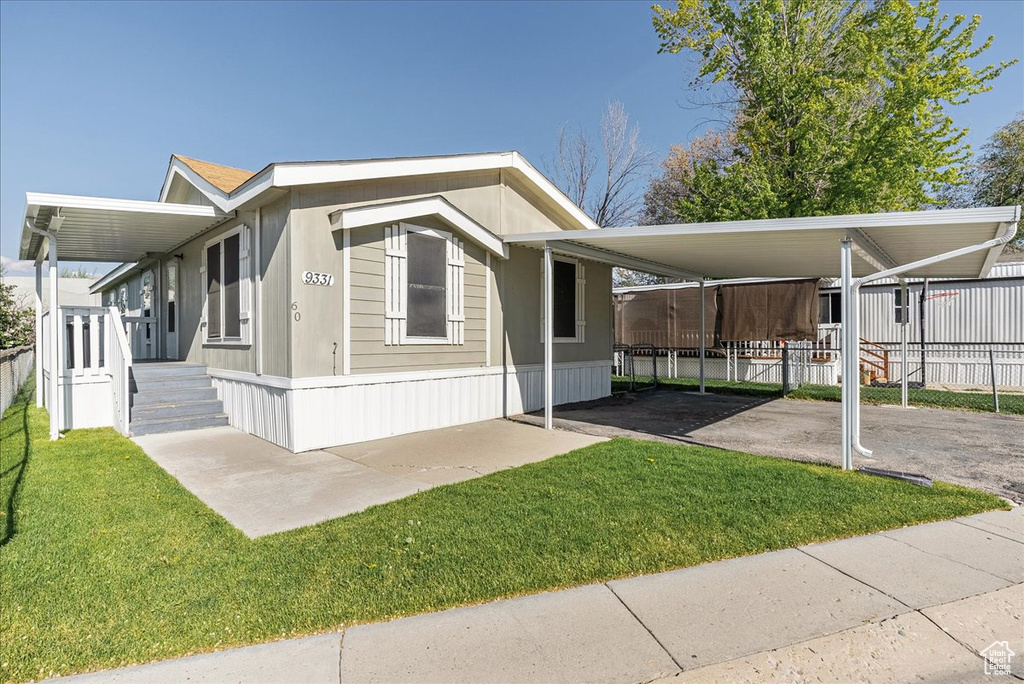 View of home's exterior with fence, a yard, and driveway