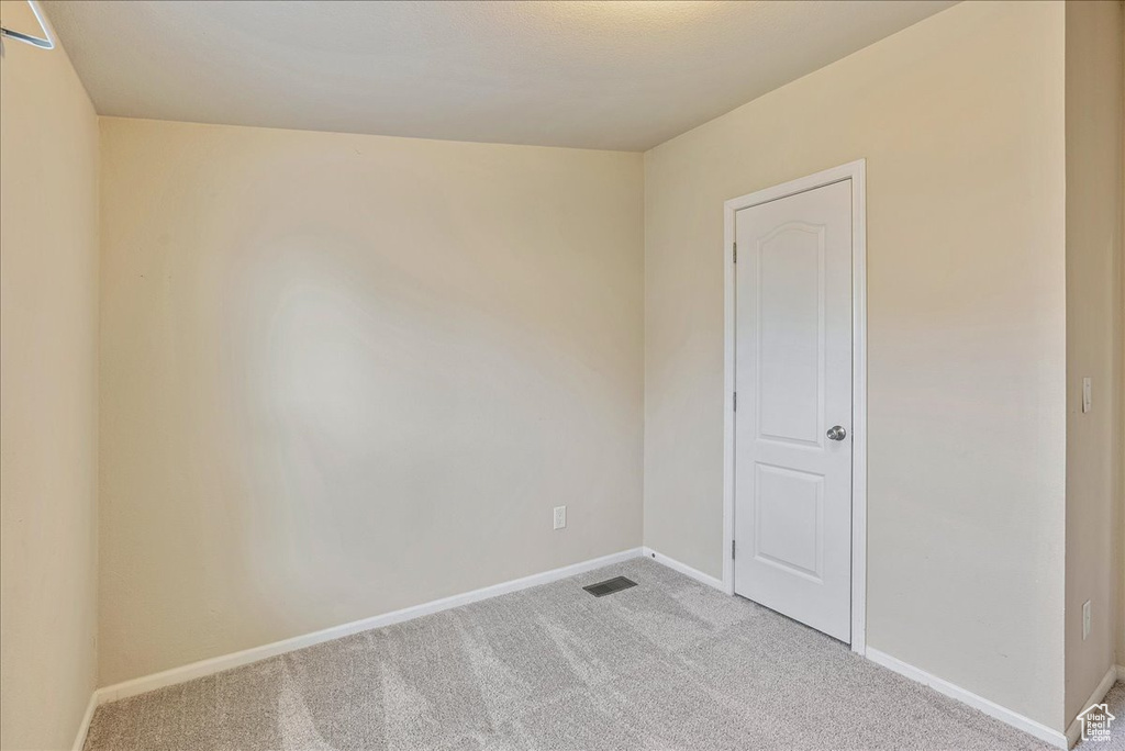 Unfurnished room featuring baseboards, light carpet, and visible vents