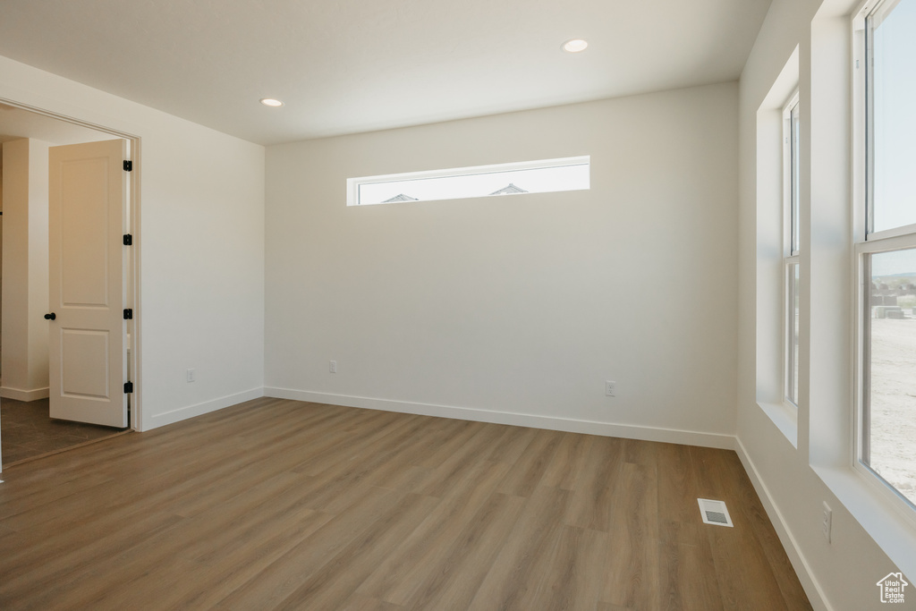Empty room with light wood finished floors, recessed lighting, and baseboards