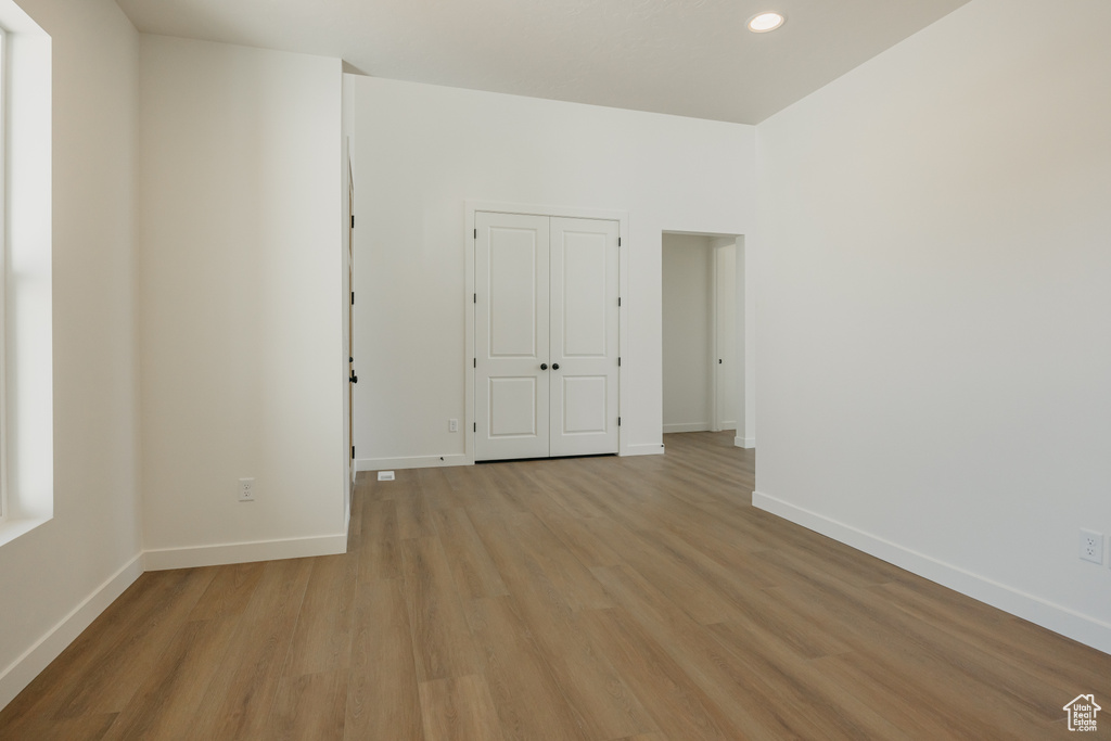 Unfurnished room featuring light wood-type flooring, baseboards, and recessed lighting