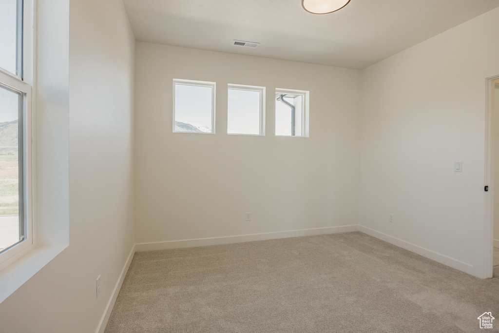 Empty room featuring light carpet and baseboards