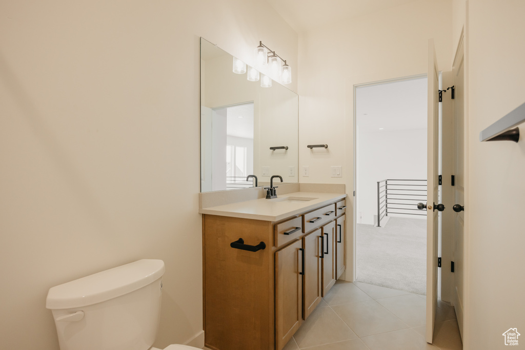 Bathroom featuring toilet, vanity, and tile patterned flooring