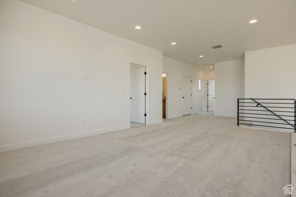 Empty room featuring light colored carpet, recessed lighting, and baseboards