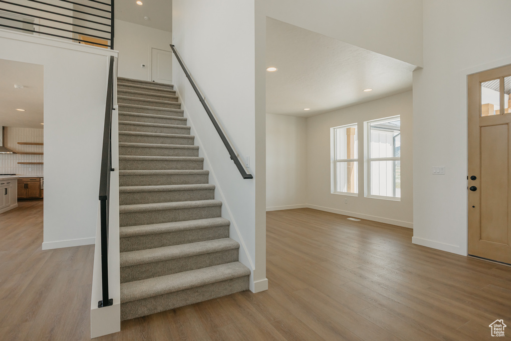 Entryway featuring light wood-style floors, stairs, recessed lighting, and baseboards