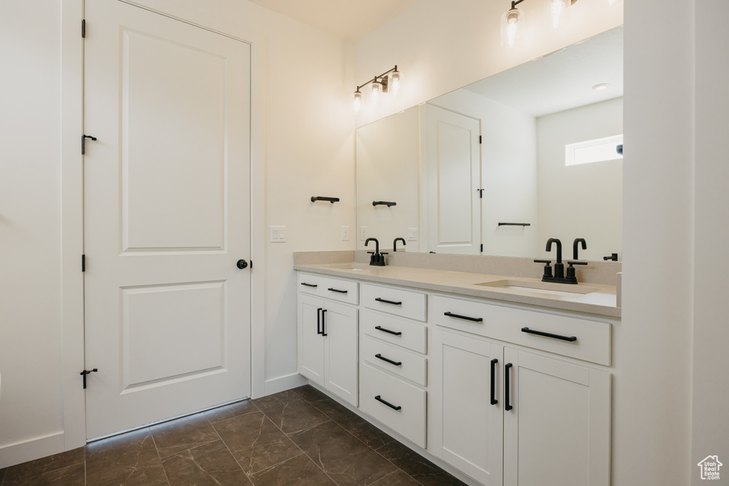 Full bath featuring marble look tiles and double vanity