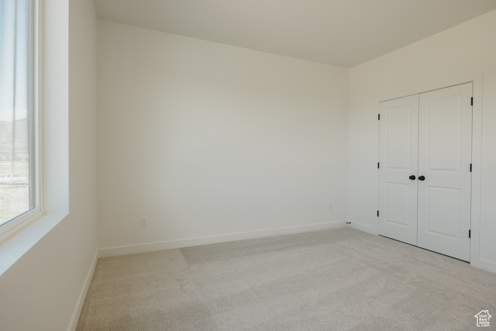 Unfurnished bedroom featuring carpet floors, baseboards, and a closet