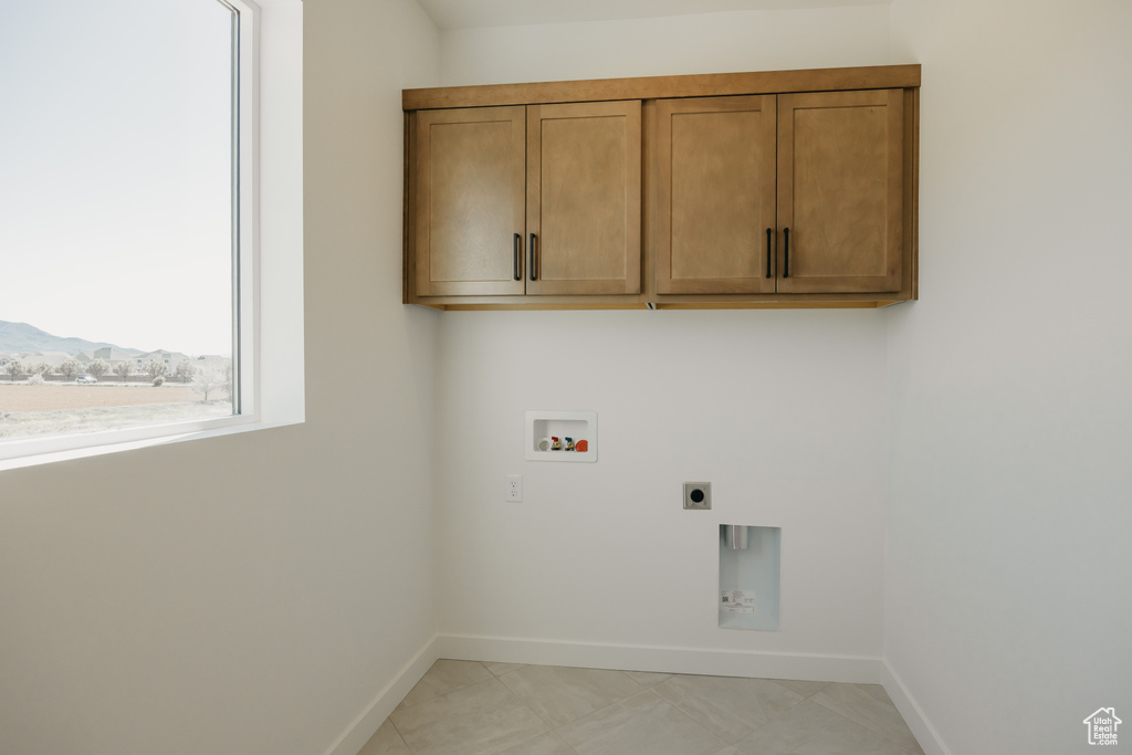 Clothes washing area with hookup for a washing machine, hookup for an electric dryer, baseboards, and cabinet space