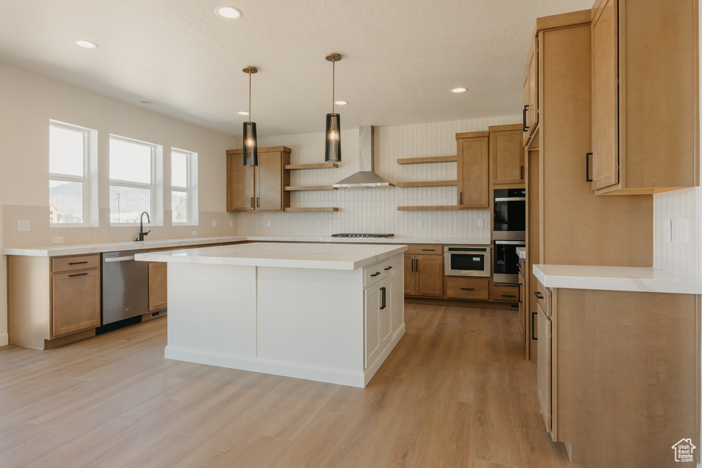 Kitchen featuring open shelves, appliances with stainless steel finishes, wall chimney exhaust hood, light wood-type flooring, and tasteful backsplash